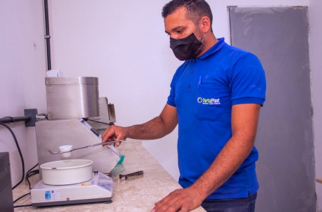 Homem pesando elementos em laboratório